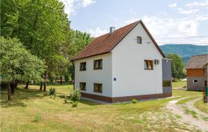 une maison blanche avec un toit marron dans l'établissement Stunning Apartment In Otocac With Wifi, à Otočac