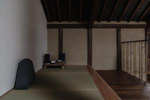 a living room with a tv and a table at 滔々 阿知の庄 蔵の宿 toutou Achinosho Kura no Yado in Kurashiki