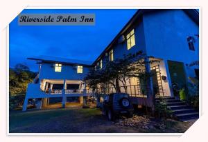 a blue house with a truck parked in front of it at RIVERSIDE PALM INN SG LEMBING in Sungai Lembing