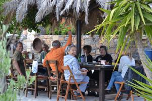 un grupo de personas sentadas en una mesa en un restaurante en Katerina Apartments en Káto Zákros