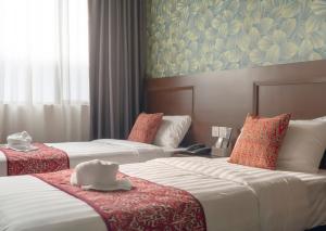 a hotel room with two beds and a painting on the wall at East Riverine Boutique Hotel in Kuala Lumpur
