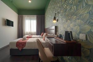 a bedroom with a bed and a desk with a computer at East Riverine Boutique Hotel in Kuala Lumpur