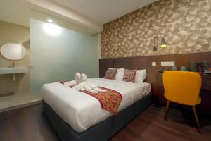 a hotel room with a bed and a yellow chair at East Riverine Boutique Hotel in Kuala Lumpur +263 photos