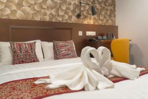 a bedroom with a bed with two swans on it at East Riverine Boutique Hotel in Kuala Lumpur