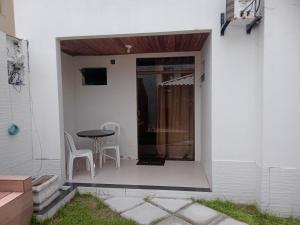 a patio with a table and chairs on the side of a house at Apts e suites em Stella Maris in Salvador