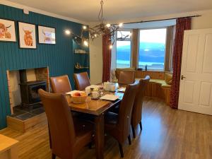 a dining room with a table and chairs and a fireplace at The Croft House in Milovaig