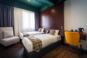 a hotel room with two beds and a chair at East Riverine Boutique Hotel in Kuala Lumpur +64 photos