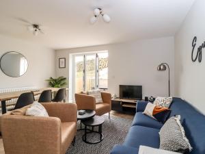 a living room with blue couches and a tv at Wising Gill House in Harrogate