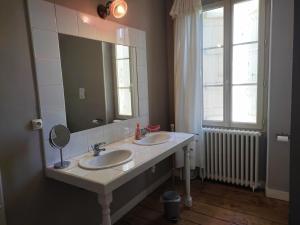 een badkamer met 2 wastafels en een grote spiegel bij Les Angelots in Condom