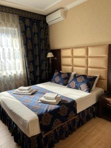 a bedroom with a bed with two towels on it at Akropol in Gelendzhik