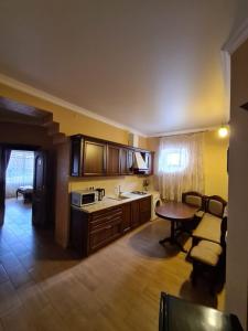 a kitchen with wooden cabinets and a table and chairs at Akropol in Gelendzhik