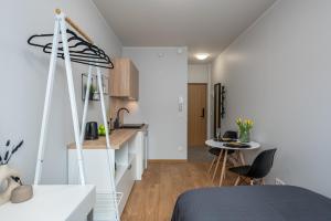 a room with a bed and a kitchen with a table at Cosy Pepleri place, self check-in in Tartu