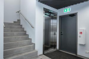a elevator in a building with a exit sign at Cosy Pepleri place, self check-in in Tartu