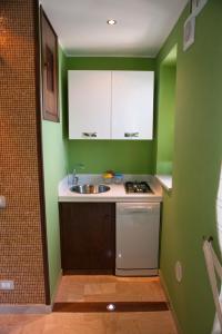 a kitchen with green walls and a sink and a dishwasher at MiraMare Residence Cefalú in Cefalù