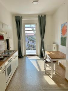 a kitchen with a wooden table and a table and a window at Downtown Chic Apartment Graz - Top 8 self check-in in Graz