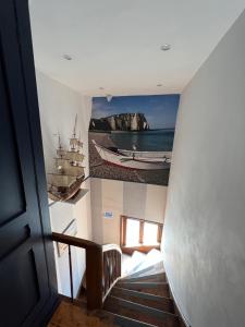 a staircase with a picture of a boat on the wall at Chambre D'hôte Villa Maurice in Étretat