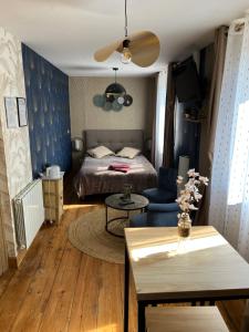 a bedroom with a bed and a table and a couch at Chambre D'hôte Villa Maurice in Étretat