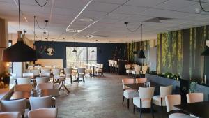 a dining room with tables and white chairs at Huisje Hygge - luxe bungalow met grote tuin in Ewijk