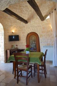 a dining room with a green table and chairs at La Rosa dei Trulli B&B in Alberobello