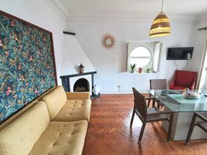 a living room with a couch and a table and a fireplace at Botanique Guesthouse in Cascais