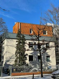 a white building with a tree in front of it at Messe Apartment Berlin in Berlin