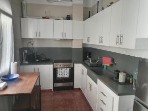 a kitchen with white cabinets and a black stove top oven at Callisto room 3 in Ermoupoli +6 photos