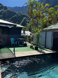 una casa con piscina con montagne sullo sfondo di L'améthyste - Bungalow de charme a Cilaos