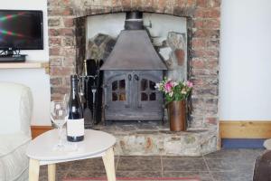 a brick fireplace with a stove in a living room at Shipwrights - Views across the Marina and River Dart, perfect bolthole in Kingswear