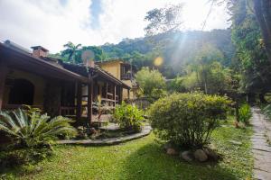 a house with a garden in front of it at Hotel da Cachoeira in Penedo