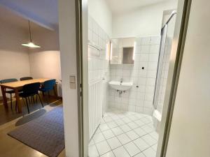 a bathroom with a sink and a toilet and a table at ARTAPART - Apartment Top 2 self check-in in Graz