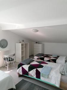 a white bedroom with a bed and a chair at Big Blue - Xenija (Veliko Plavetnilo - Ksenija) in Metajna