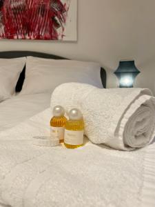 ein Bett mit weißen Handtüchern und 2 Flaschen Honig in der Unterkunft ARTAPART - Apartment Top 2 self check-in in Graz
