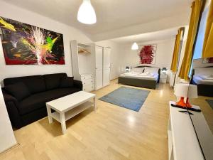 ein Wohnzimmer mit einem Sofa und einem Bett in der Unterkunft ARTAPART - Apartment Top 2 self check-in in Graz