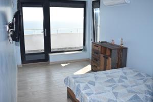 a bedroom with a bed and a dresser and windows at Вила “Здравец” in Fish Fish