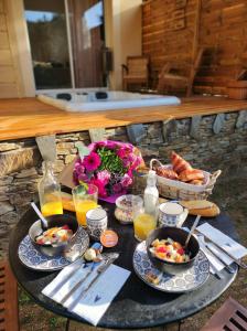 uma mesa com pratos de comida numa mesa com bebidas em Magnifique petite villa haut de gamme avec jacuzzi l'attrape rêve em Les Plantiers