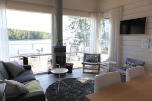 a living room with a fireplace and a large window at Villa Jolla in Padasjoki