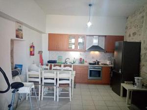 a kitchen with a table and chairs and a refrigerator at H&M Prive HOME MÀRGARITES RETHYMNO 115sqm in Margarítai