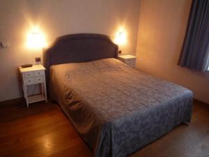 1 dormitorio con 1 cama con 2 mesitas de noche y 2 lámparas en Le Château de Rendeux en Rendeux
