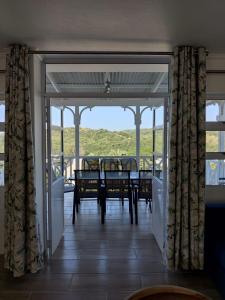 a dining room with a table and chairs on a balcony at 44 Montego Bay Caribbean Estates in Port Edward