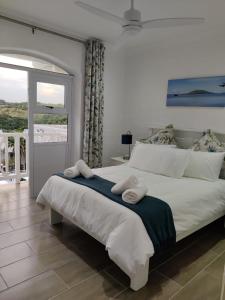 a bedroom with a large bed with towels on it at 44 Montego Bay Caribbean Estates in Port Edward