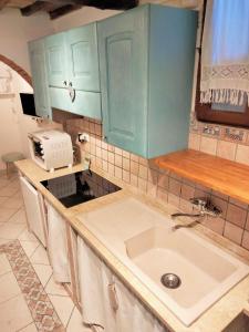 kuchnia z niebieskimi szafkami i zlewem w obiekcie Appartamento La Maison w mieście Capoliveri +37 zdjęć