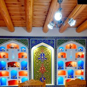 Habitación con suelo de baldosa azul y verde y techo. en Koh-i-noor, en Bukhara