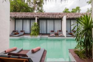 a swimming pool with lounge chairs in a resort at The Flow Samui Beach Resort in Mae Nam