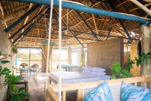 Postel nebo postele na pokoji v ubytování Kizingo Beach Eco Lodge