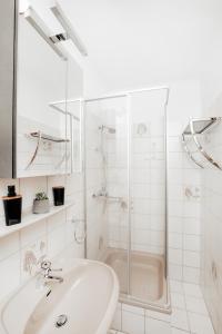 ein weißes Bad mit einer Dusche und einem Waschbecken in der Unterkunft Ferienhaus Heidedorf in Winterberg