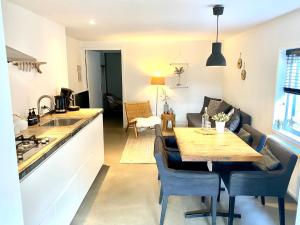 a kitchen and living room with a wooden table in a room at ZILT sous in Noordwijk