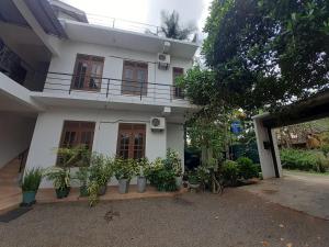 een wit huis met planten ervoor bij Emarald Holiday Homes in Anuradhapura