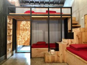 a room with two bunk beds with red sheets at 破豆基地 in Kaohsiung