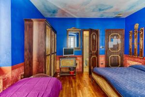 a bedroom with blue walls and a bed and a tv at Hotel Portacavana in Trieste