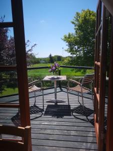 a patio with a table and chairs on a deck at Hvirrekærgaard, midt i naturen. in Hirtshals